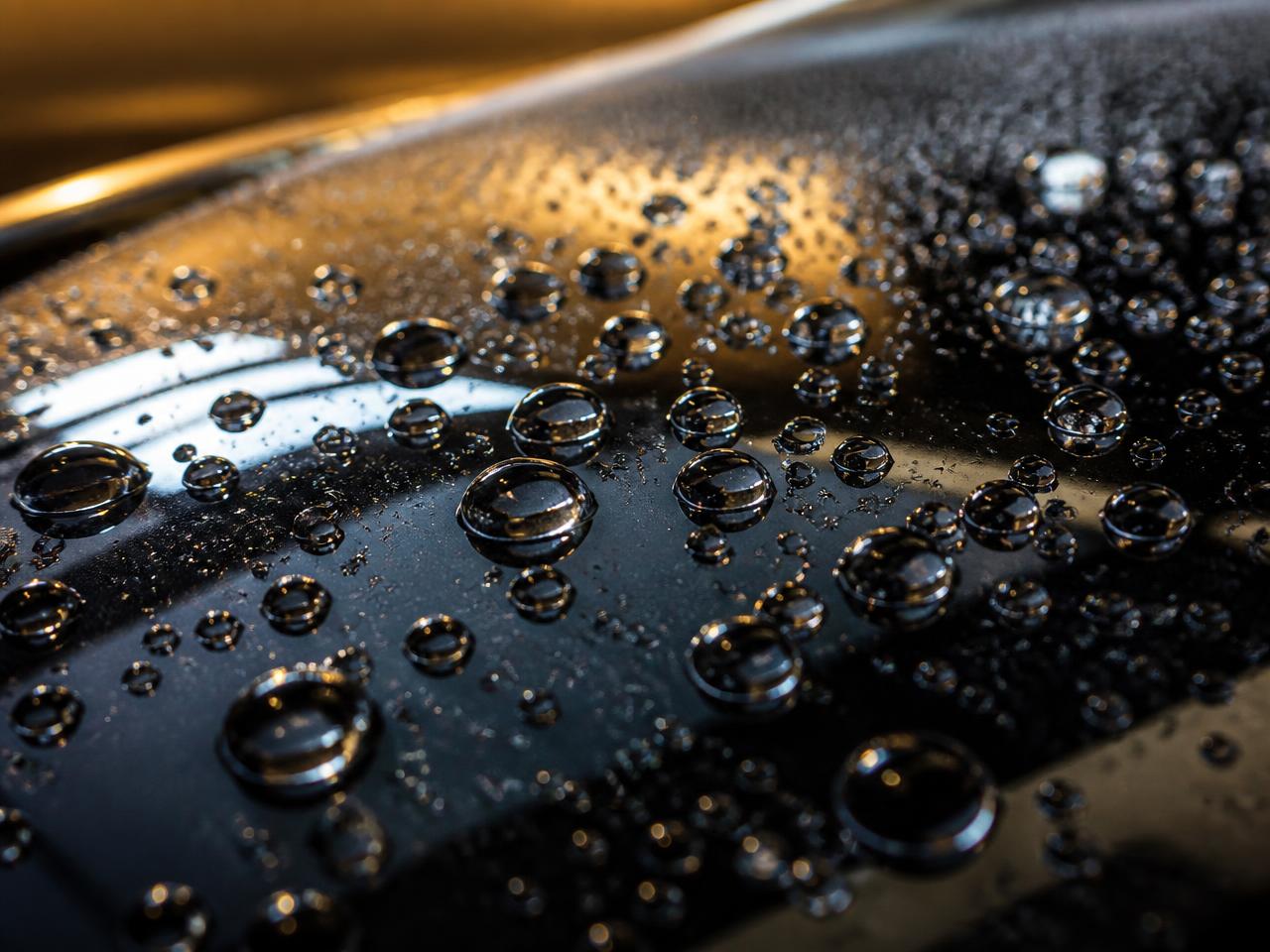 Gotas de água formando esferas sobre pintura preta encerada com Brill Car